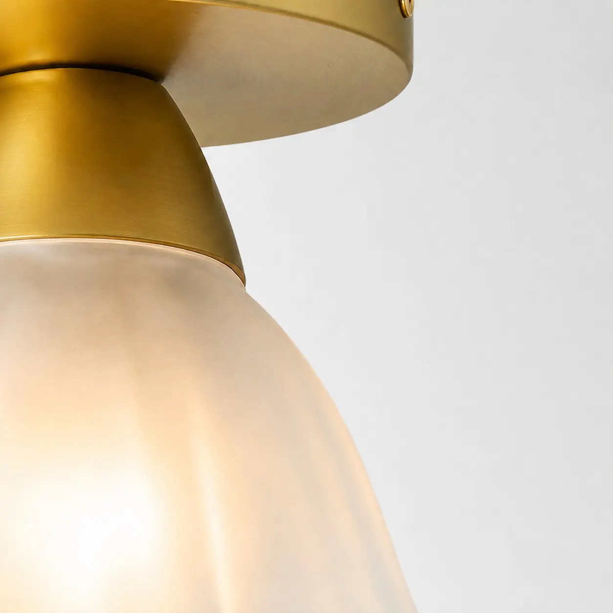 Brushed gold lamp holder and frosted glass connection detail