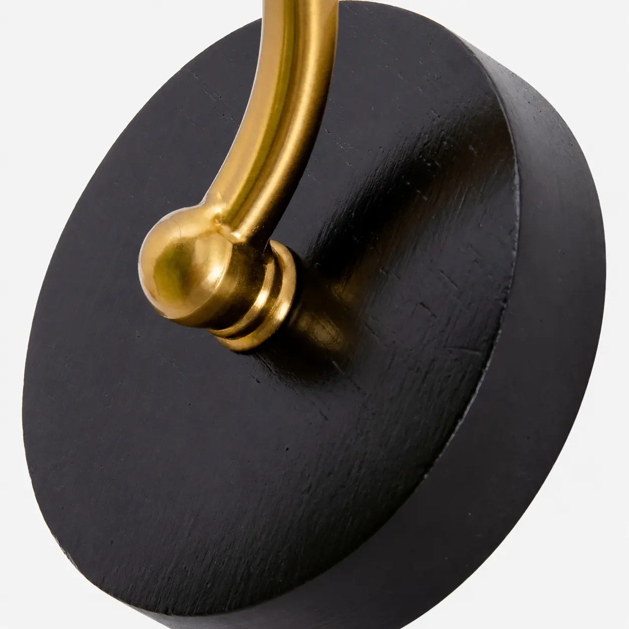 Round dark wall plate and brass connection detail